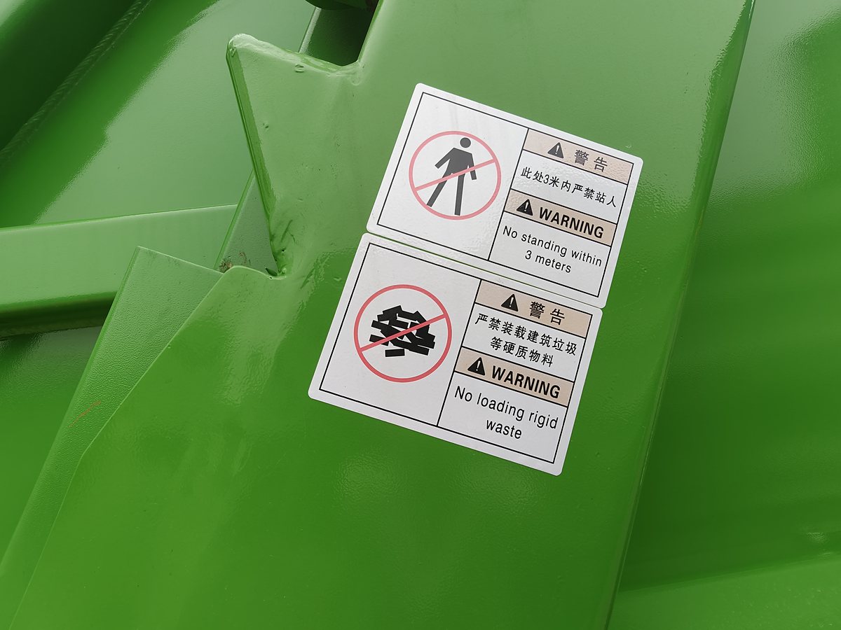 压缩式垃圾车厢体安全警示标识特写（禁止站人、禁止装载建筑垃圾）